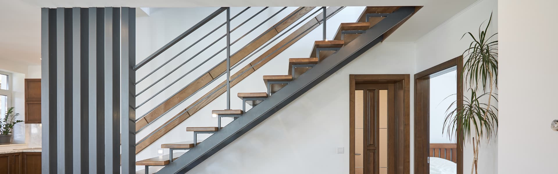 Interior staircase with wood treads and custom iron handrails inside a residential home.