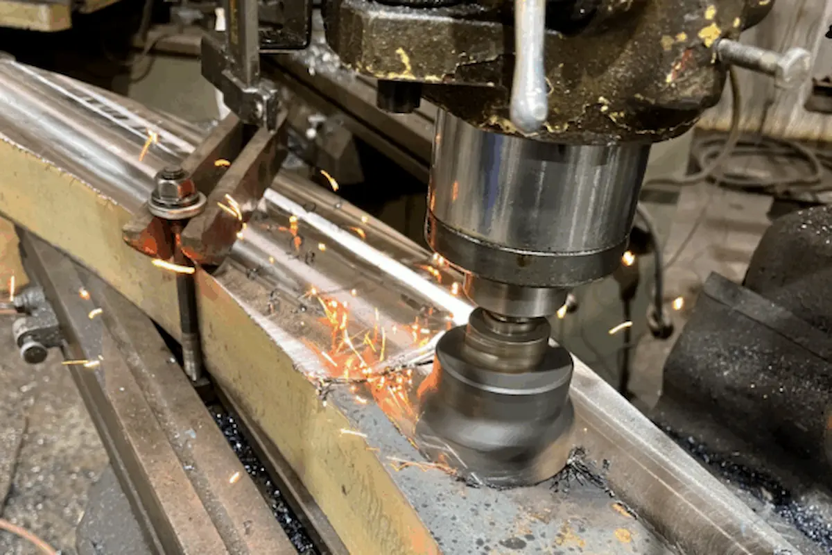 A precision machining drill operating on metal in a machine shop.