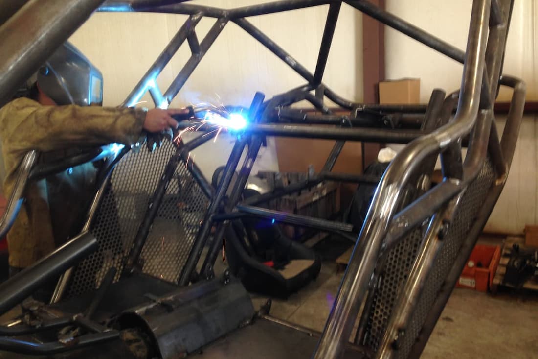 A technician at WiseCo Welding & Machine fabricates a custom roll cage for an off-road vehicle. WiseCo provides precision welding, fabrication, and custom metal work for racing, off-road, and industrial applications across Sedalia and Mid-Missouri.